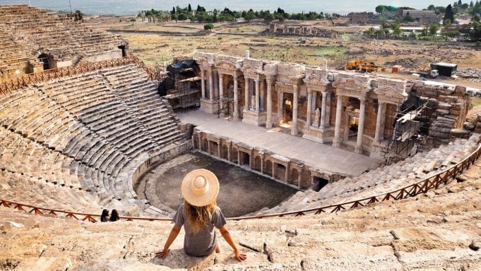 Tourist sitting and admiring the ancient Hierapolis theater.