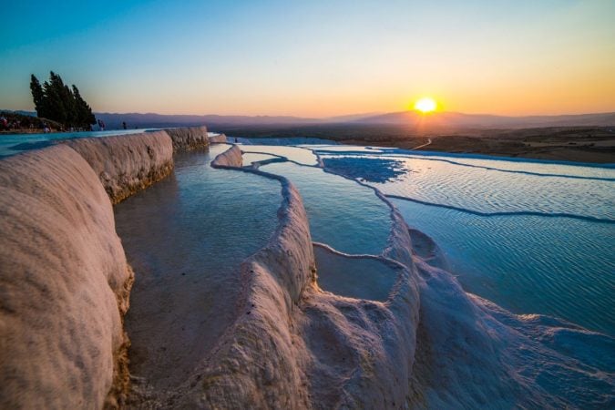 Blue terraces of Pamukkale reflecting the sunset sky.