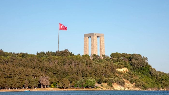 Turkish memorial with national flag flying on a hill during Gallipoli tours in Turkey