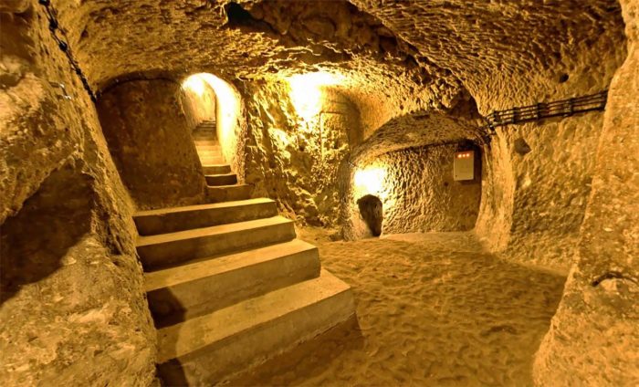Stone stairs leading through a narrow tunnel inside Derinkuyu Underground City in Cappadocia.