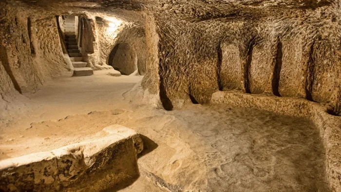 Stable-like room with feeding troughs carved into rock inside Kaymakli Underground City, Cappadocia.