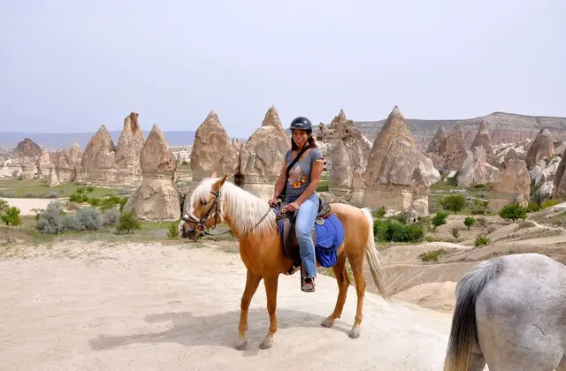 Sei cavalieri in una soleggiata Cappadocia con i camini delle fate sullo sfondo