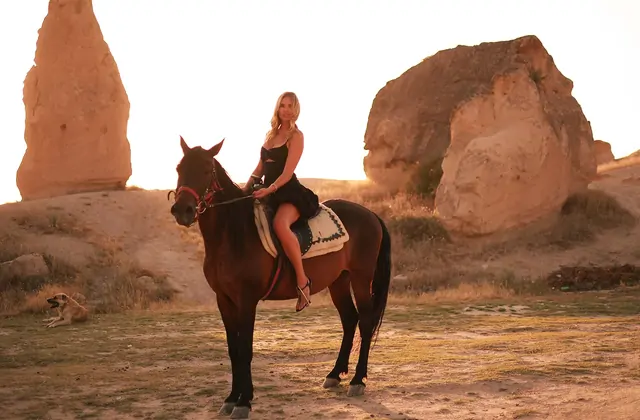 Donna a cavallo da sola con vista sulle creste montuose della Cappadocia