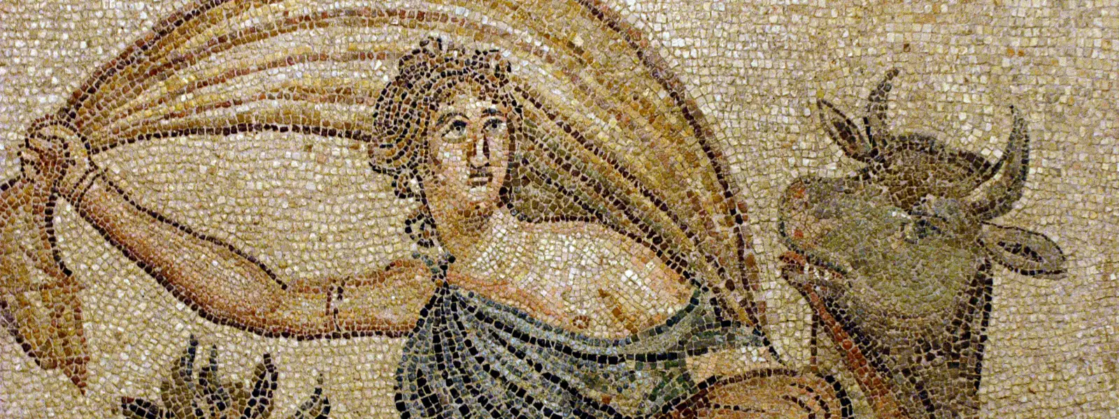 Un mosaico romano de Zeugma en el museo de Gaziantep representa el mito de Europa — una figura femenina con manto se aferra a una tela ondeante mientras monta un toro, con motivos de criaturas marinas en el fondo de teselas color ámbar y arena.