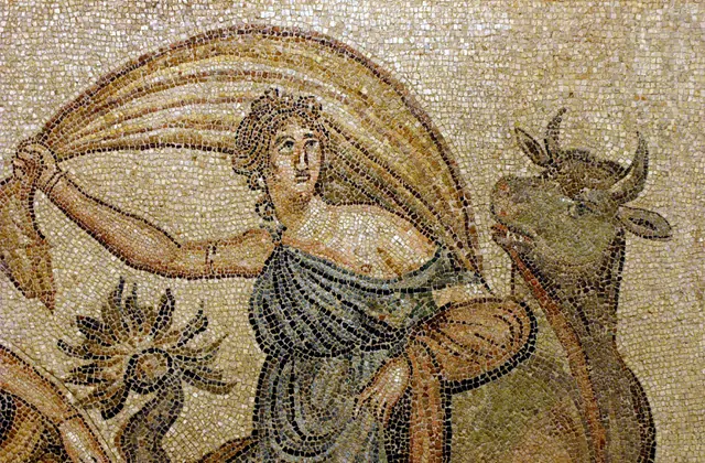A Roman mosaic from Zeugma at Gaziantep's museum depicts the myth of Europa — a draped female figure clutches a billowing garment while riding a bull, with sea-creature motifs in the warm amber and sandy tesserae background.