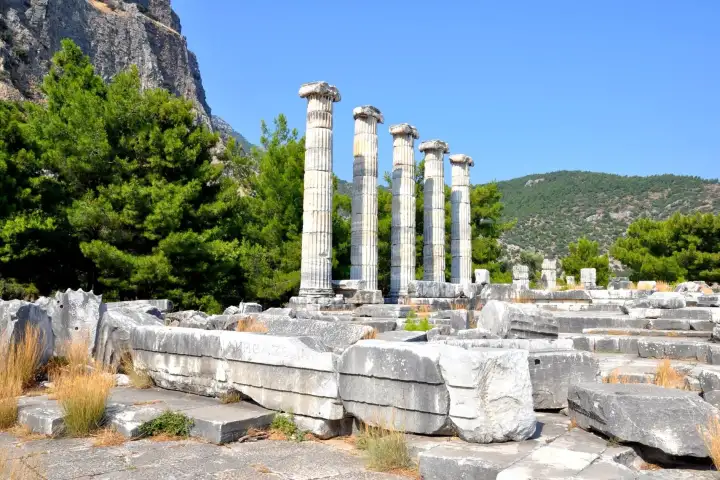 Ruins and columns of the Temple of Athena in Priene under a clear sky