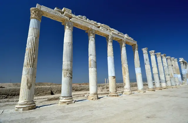 Calle porticada de la ciudad antigua de Laodicea en Denizli, Turquía, con una larga fila de columnas romanas de mármol bajo un cielo despejado