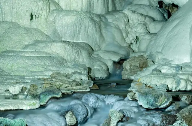 Formaciones blancas de travertino y pozas minerales dentro de la cueva de Kaklik, Denizli, Turquía, modeladas por el flujo de agua termal