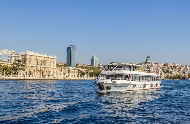 Un ferry turístico navega cerca de la costa de Estambul en un crucero por el Bósforo, mostrando el carácter costero de la ciudad con elegantes edificios, vistas al mar y un paisaje urbano inolvidable.