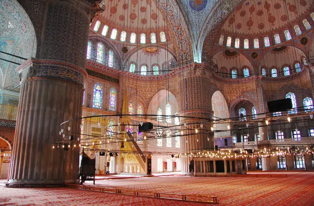 Sala de oración de la Mezquita Azul con alfombra roja en Estambul