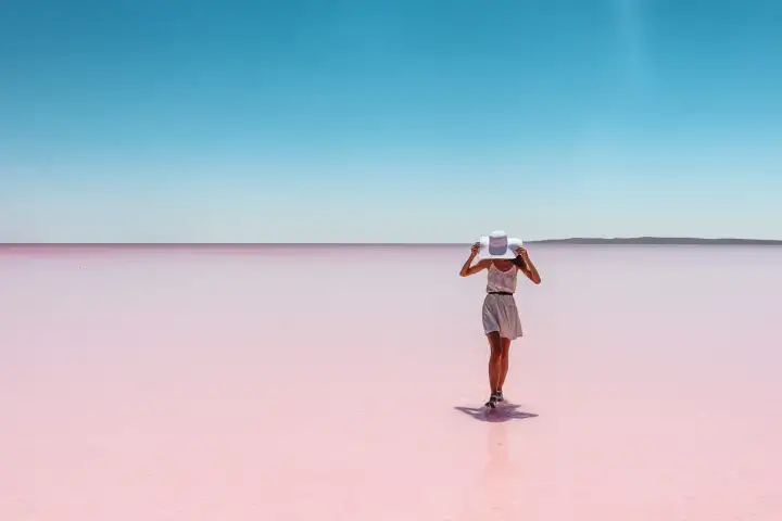 Mujer caminando sobre la llanura rosada de sal en el Lago Salado de Turquía