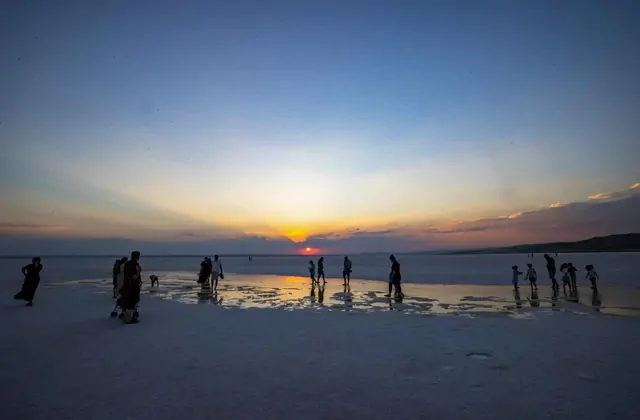 Siluetas de personas al atardecer en el Lago Salado de Turquía