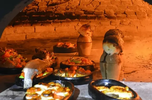 Platos locales cocinándose en un horno de piedra durante una clase de cocina en Capadocia