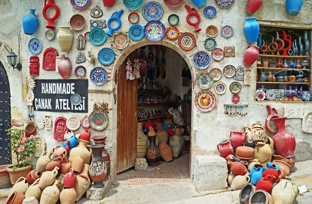 Vasi in ceramica finiti smaltati in tonalità terrose decorano il davanzale di un negozio di ceramiche ad Avanos lungo il percorso del Red Tour della Cappadocia.
