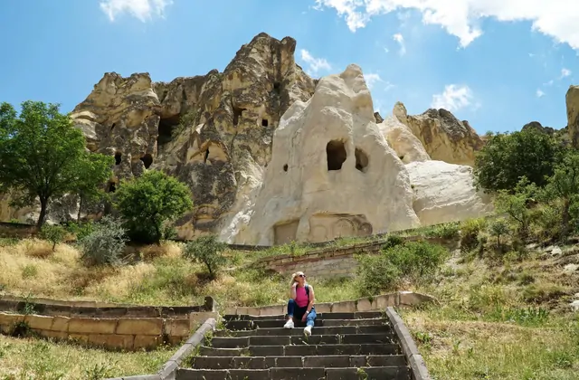 Turisti che leggono pannelli informativi davanti alla Chiesa Tokalı nel Museo all'Aperto di Göreme, la più grande chiesa rupestre della Cappadocia nell'itinerario del Red Tour.