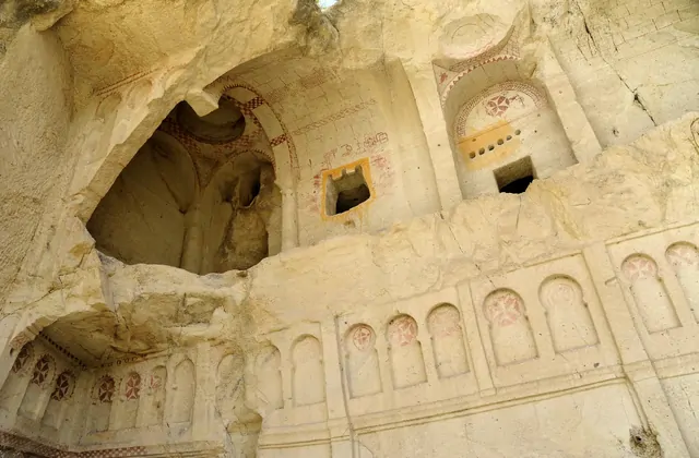 Una guida spiega la storia del primo Cristianesimo a un gruppo del Red Tour all'ingresso di una chiesa rupestre nel Museo all'Aperto di Göreme, Cappadocia.