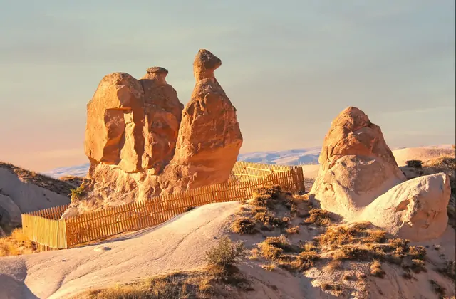Un viajero solitario de pie entre imponentes formaciones de chimeneas de hadas en el Valle Devrent, Capadocia, ilustrando la dramática escala de este paisaje del Red Tour.