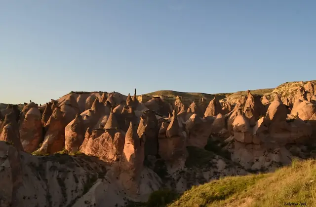 Estratos volcánicos en capas visibles en una sección transversal de una chimenea de hadas rota en el Valle Devrent, revelando la antigua historia geológica de Capadocia en el Red Tour.