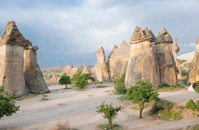 Silhouette al tramonto dei camini delle fate a tripla testa a Paşabağ contro un cielo cremisi della Cappadocia, un'immagine finale indimenticabile del Red Tour.