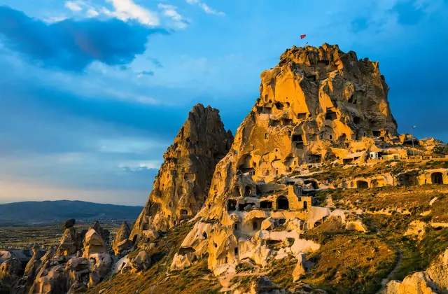 The honeycombed exterior of Üçhisar Castle with dozens of carved windows and tunnel openings, a remarkable rock-cut architecture highlight on the Cappadocia Red Tour.