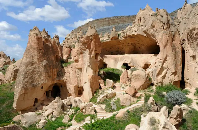 La torre della chiesa in rovina del Museo all'Aperto di Zelve vista attraverso un'apertura ad arco di una grotta, che incornicia una classica fotografia architettonica del Red Tour della Cappadocia.
