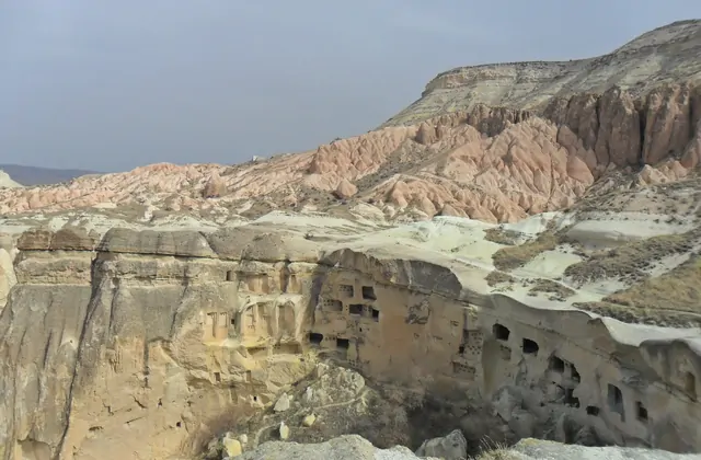 Facciata rupestre di un'antica abitazione a Çavuşin, Cappadocia, con caratteristici portali ad arco e pareti di tufo eroso, esplorate durante il Cappadocia Yellow Tour.