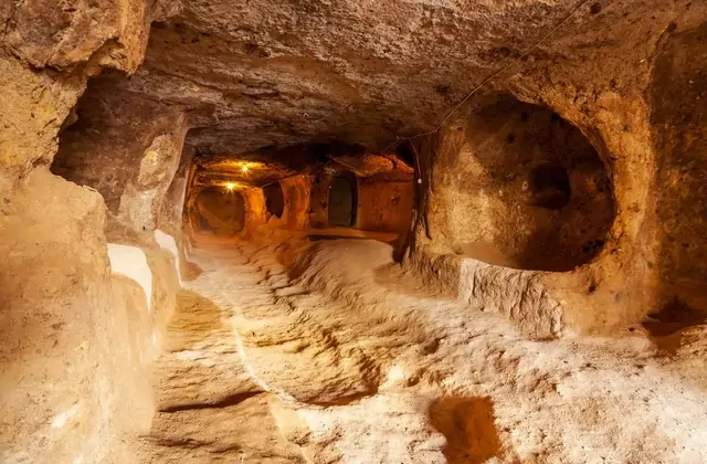 Porta in pietra rotolante nella Città Sotterranea di Özkonak, Cappadocia, usata per sigillare i tunnel contro gli invasori — un'opera ingegneristica unica scoperta nel Cappadocia Yellow Tour.