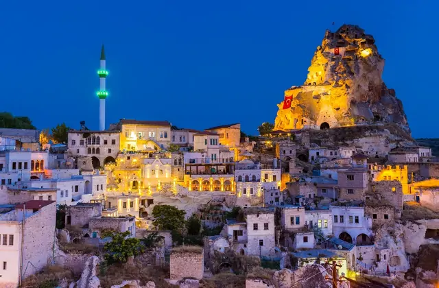 The distinctive summit of Ortahisar Castle in Cappadocia framed by a clear sky, its honeycombed walls and ancient stairways explored during the Cappadocia Yellow Tour.