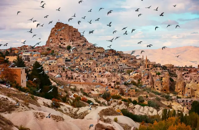 Golden tuff cliffs of Pigeon Valley near Uchisar Castle, Cappadocia, glowing in the afternoon light during the Cappadocia Yellow Tour half-day excursion.
