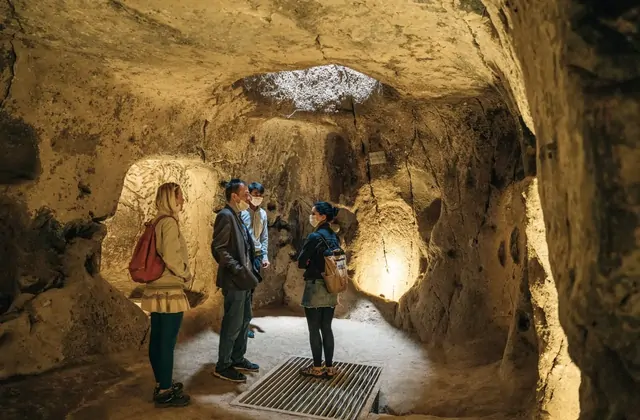 Carved arch entrance to a side chamber in Özkonak Underground City, Cappadocia, its smooth tuff walls showing the precision of ancient stone carving on the Yellow Tour.