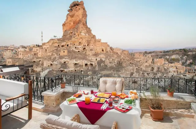 Wide panorama from Ortahisar Castle's summit in Cappadocia, taking in Erciyes volcano on the horizon and the patchwork of vineyards below — the ultimate Yellow Tour vantage point.