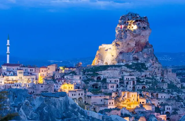 Ortahisar Castle and its surrounding town viewed from the valley road in Cappadocia, showing the dramatic scale of the tuff rock citadel rising 86 metres above the village on the Yellow Tour.