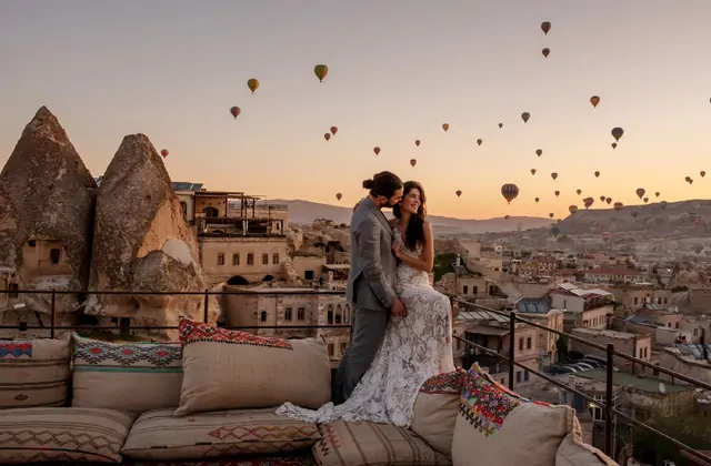 La luz de la hora dorada inunda el Valle del Amor en Capadocia, Turquía, proyectando largas sombras cálidas desde los altos pilares de roca columnares mientras los globos aerostáticos derivan perezosamente en el cielo luminoso.