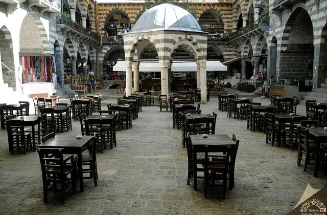 I visitatori pranzano in un cortile a volta coperta dell'antico bazar di Diyarbakır, dove le volte in pietra offrono frescura sulle tavole disposte tra colonne di basalto intagliato, momento clou di qualsiasi tour guidato nella città vecchia.