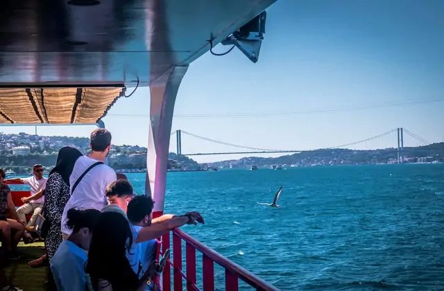 Turistas en un crucero guiado por el Bósforo de Estambul contemplan el reluciente estrecho mientras un enorme puente lo cruza por encima, uniendo las orillas europea y asiática de Turquía.