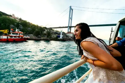 A close-up view from the deck railing of a guided Istanbul Bosphorus cruise captures the open waterway stretching ahead, evoking the feeling of sailing between two continents on a classic Turkish boat tour.