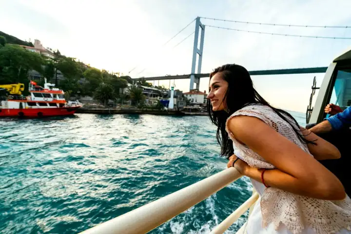 A close-up view from the deck railing of a guided Istanbul Bosphorus cruise captures the open waterway stretching ahead, evoking the feeling of sailing between two continents on a classic Turkish boat tour.