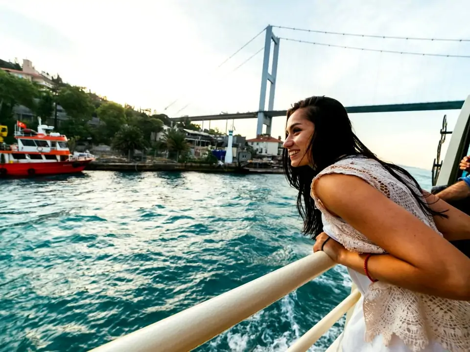 A close-up view from the deck railing of a guided Istanbul Bosphorus cruise captures the open waterway stretching ahead, evoking the feeling of sailing between two continents on a classic Turkish boat tour.