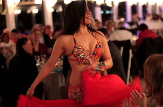 Intrattenimento dal vivo con danza del ventre durante una cena in crociera sul Bosforo a Istanbul, con le ballerine che animano il palco mentre gli ospiti godono di un festoso spettacolo di cena turca sull'acqua.