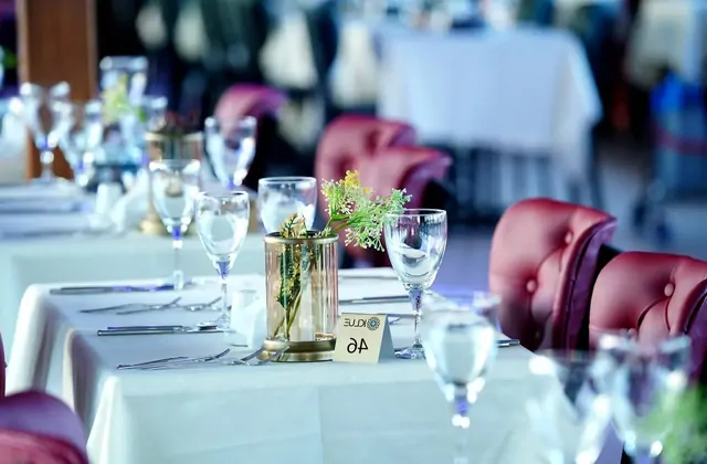 Un tavolo da pranzo fine elegantemente apparecchiato a bordo di una cena in crociera sul Bosforo a Istanbul, con tovaglie bianche e bicchieri disposti per un'esperienza gastronomica premium sullo stretto.