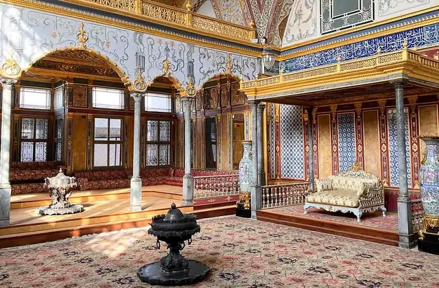 La Sala del Consiglio Imperiale (Hünkar Sofası) del Palazzo Topkapi di Istanbul è riccamente adornata con rivestimento di piastrelle di Iznik blu dal pavimento al soffitto, fregi di calligrafia dorata e archi scolpiti, con un podio del trono imbottito a destra, elaborate tappeti orientali che copron