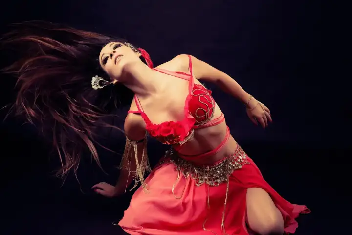Danzatrice del ventre professionista in un accattivante costume rosso che si esibisce dal vivo sul palco della celebrazione di Capodanno Sultanas a Istanbul. Intrattenimento tradizionale turco che rende il Capodanno a Istanbul un'esperienza davvero indimenticabile.