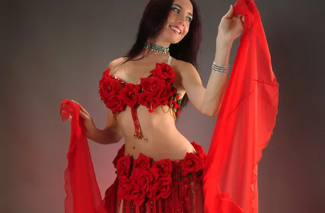 Danzatrice del ventre di Istanbul che fa vorticare con grazia un fluente foulard di seta rossa durante un affascinante spettacolo di Capodanno in Turchia al Sultanas. La vivida seta cremisi aggiunge un tocco drammatico a questo intrattenimento simbolo della festa di Capodanno di Istanbul.