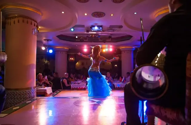 Compagnia di danza del ventre Sultanas che si esibisce su un palco completamente illuminato in vivaci costumi blu durante la celebrazione di Capodanno a Istanbul. Lo spettacolo scenico abbagliante è il fulcro di questa serata di gala di Capodanno di prim'ordine in Turchia.