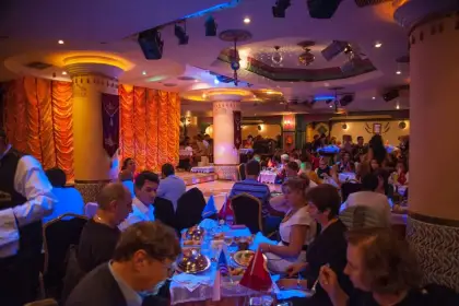 Elegantly decorated gala dinner ballroom set for the Sultanas Istanbul New Year celebration, with round tables dressed in fine linen and ambient lighting creating a luxurious New Year's Eve Turkey atmosphere. The perfect venue to welcome the New Year in Istanbul.