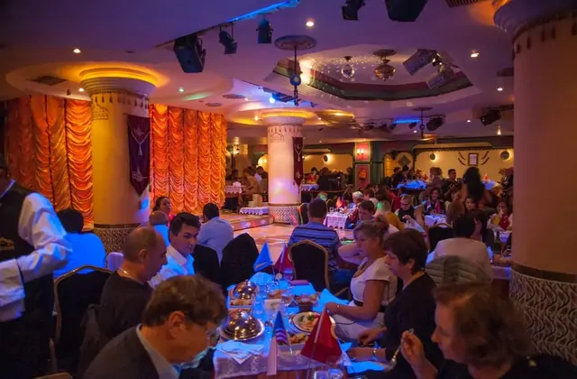 Elegante sala da ballo per la cena di gala allestita per la celebrazione di Capodanno Sultanas a Istanbul, con tavoli rotondi coperti da pregiata biancheria e illuminazione d'atmosfera che creano un'atmosfera lussuosa di Capodanno in Turchia. Il luogo perfetto per accogliere il Nuovo Anno a Istanbul