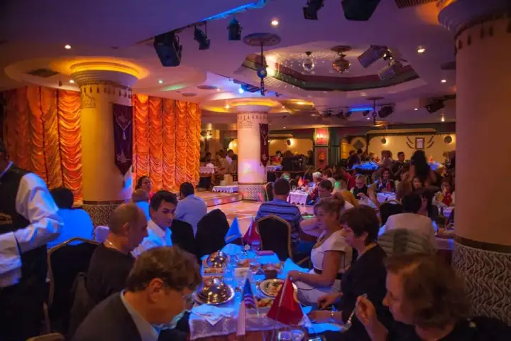 Salón de baile de gala elegantemente decorado para la celebración de Año Nuevo Sultanas en Estambul, con mesas redondas vestidas con lino fino e iluminación ambiental que crean una lujosa atmósfera de Nochevieja en Turquía. El lugar perfecto para dar la bienvenida al Año Nuevo en Estambul.